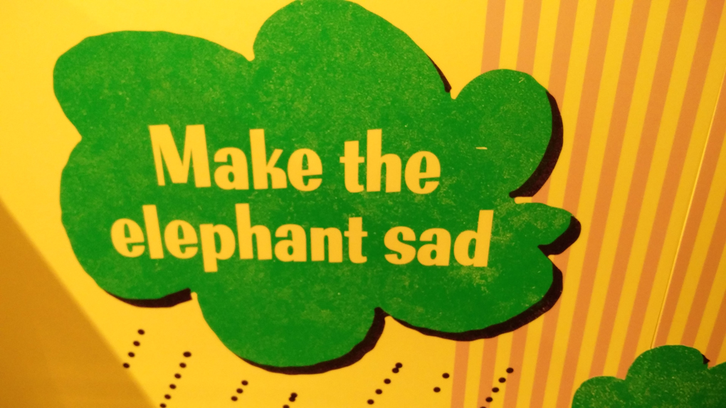 sign reading make the elephant sad