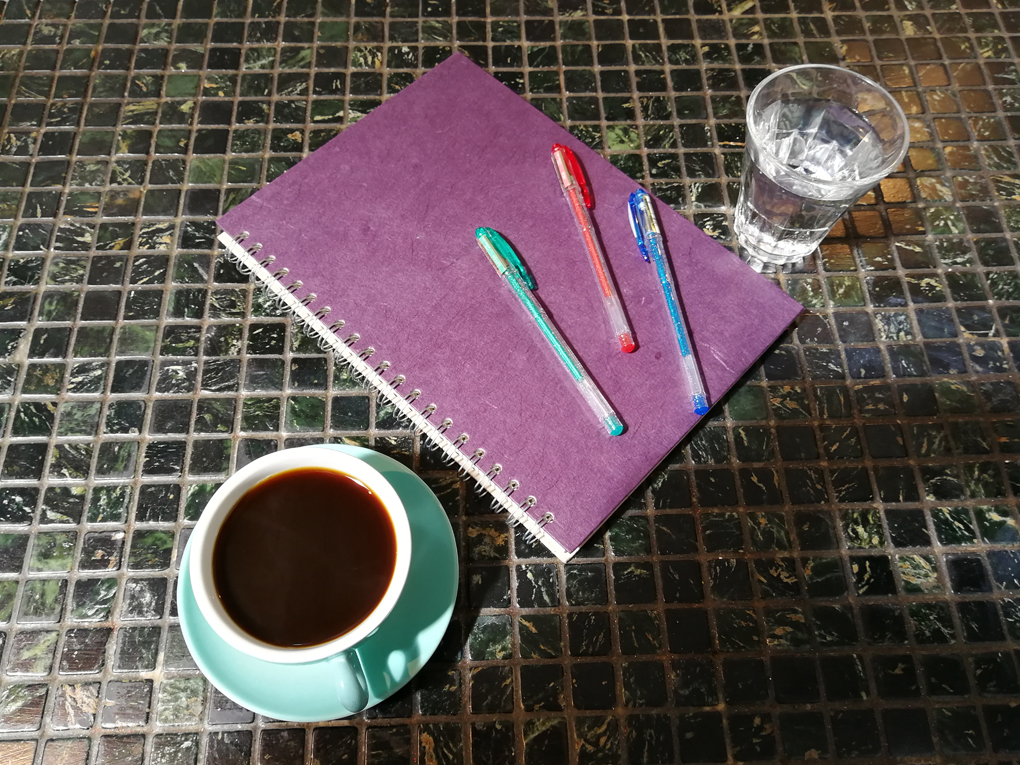 pen, notebook and coffee on a table