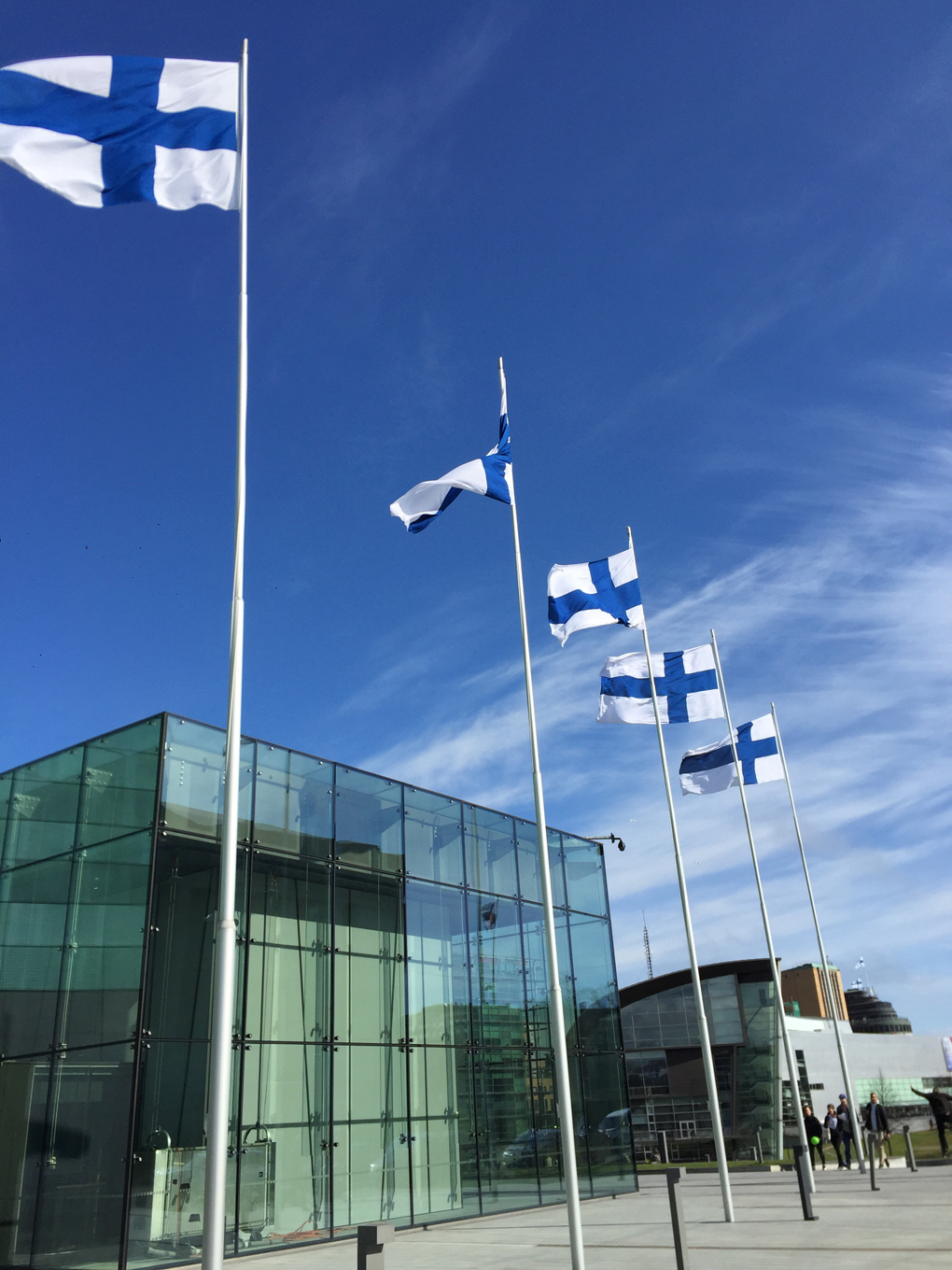 Finnish flags in a row outside a modern building