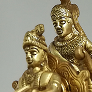 A golden statue of what I assume is Krishna, Arjuna and Hanuman, from the Mahabharata.