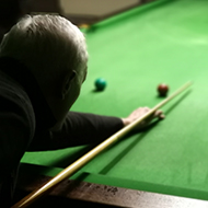 man playing snooker shot over his shoulder