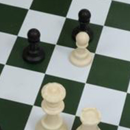 A chess game in its late stage viewed from above. The board is on a table in an office lunch area.