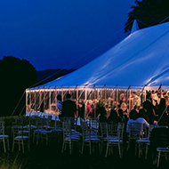Wedding reception in field; lights and marquee