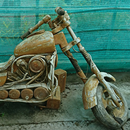 A crazy and brilliantly made Easy Rider motorbike with extended forks, parked in a quirky garden centre, looking a bit worse for wear, needing a bit of a refurb - all cleverly made of wood but not for sale!