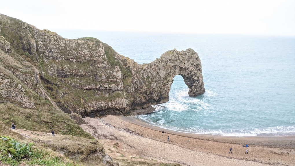 Durdle Door, a natural limestone arch, reaching out into the sea in Dorset.