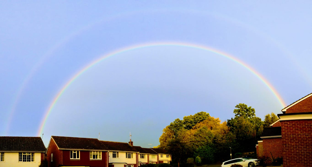 complete arch rainbow over houses