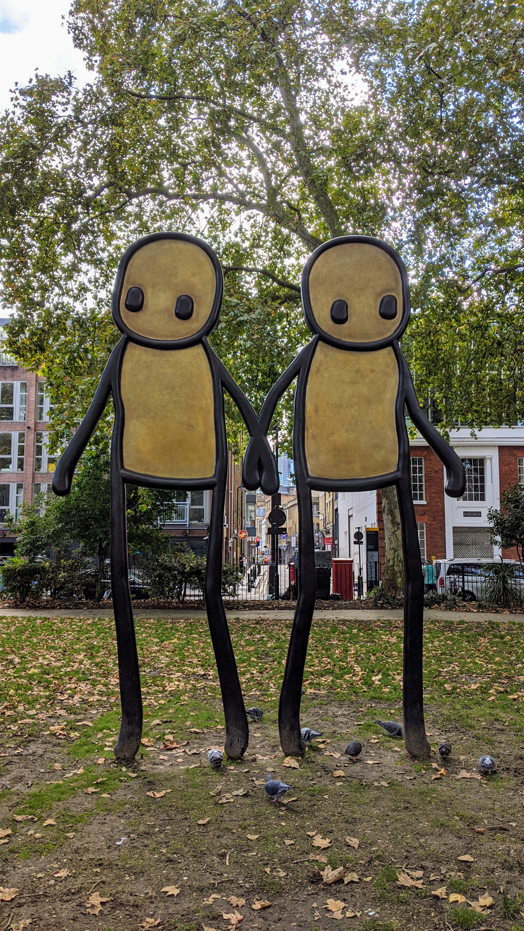 A tall sculpture of two stick figures holding hands.