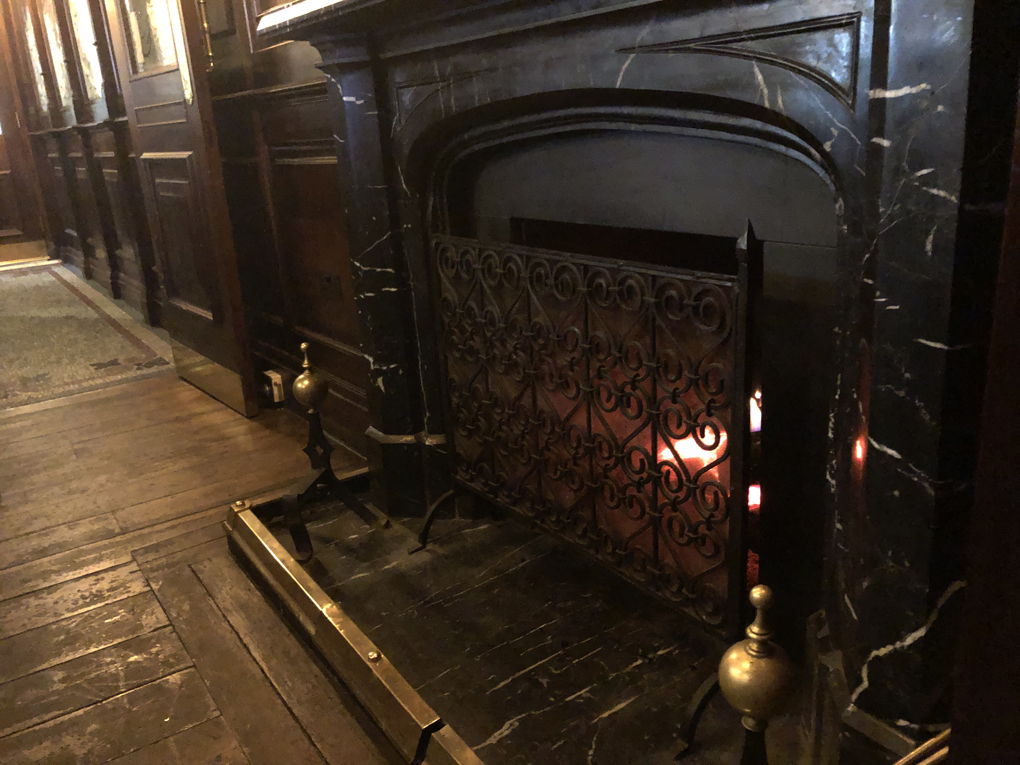 Open fire in fireplace in wooden panelled room