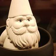 white gnome sitting in a small bowl