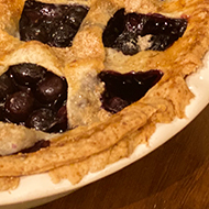 A blueberry pie looking pretty damn amazing except for some ragged edges on the crust where it kind of looks like a critter trying to escape being devoured by a slime monster