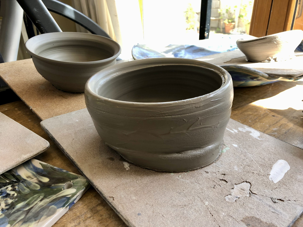 A recently-thrown pot, leaning heavily to one side.