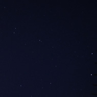 Abstract photo of sky, aerials, wall, with a few stars from Ursa Major in the middle.