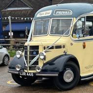 We see a 3/4 view of a restored 1950s Bedford coach