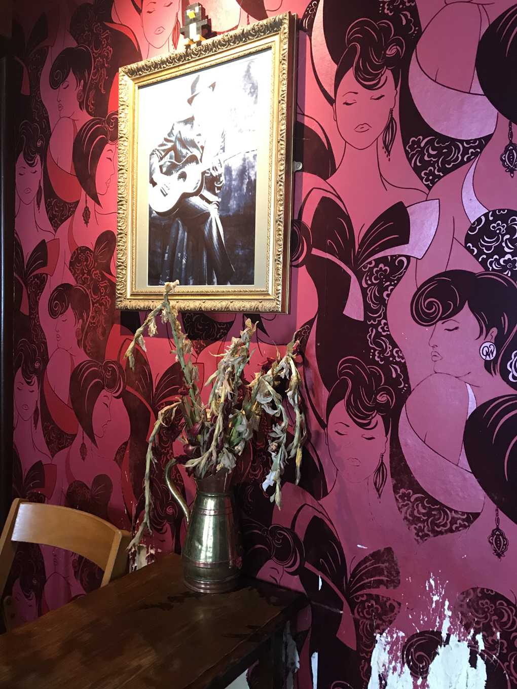 painting on wall covered in purple wallpaper