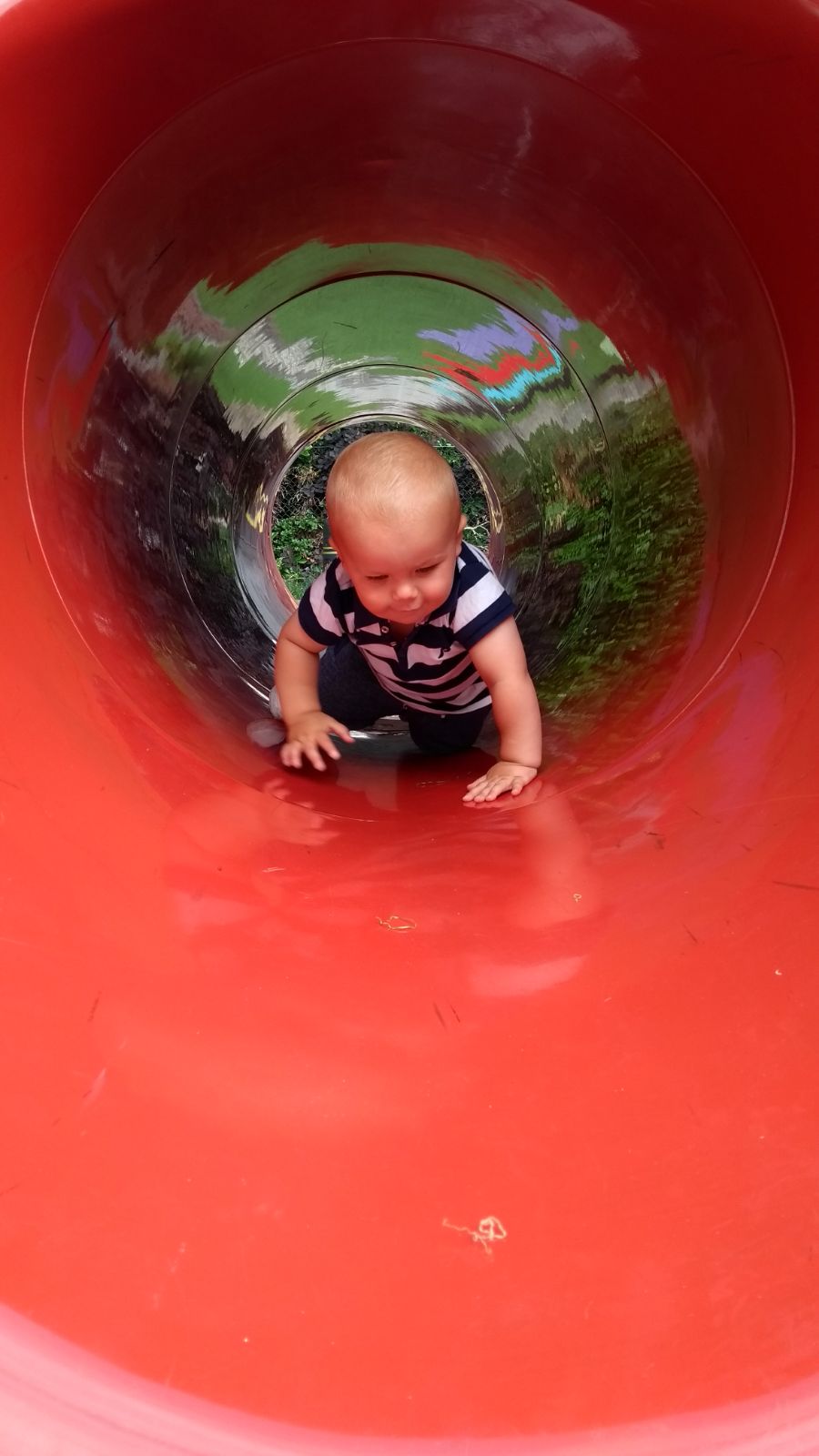 baby crawling through red tunnel