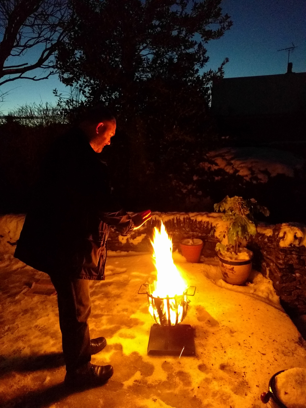 man by brazier in the snow