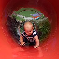 baby crawling through red tunnel