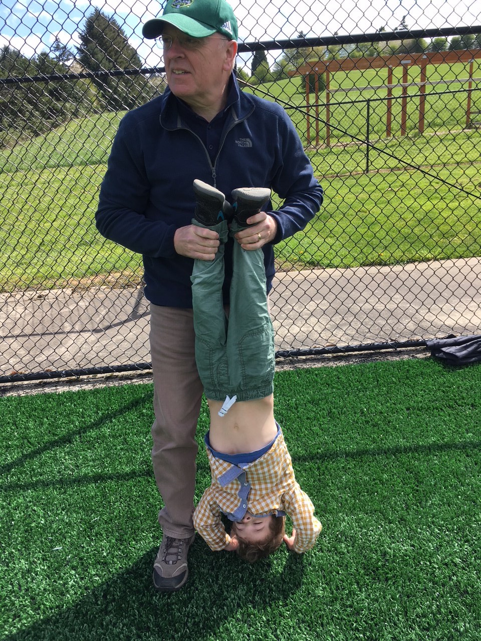 man holding child upside down