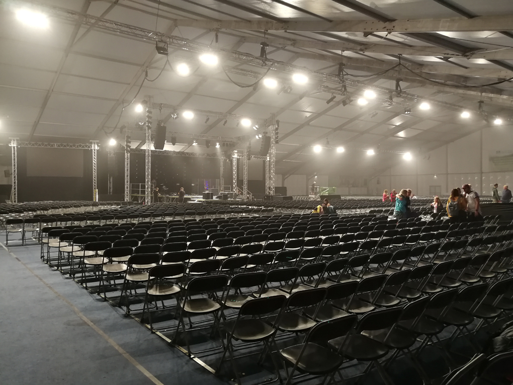 a large tent with empty seating and stage