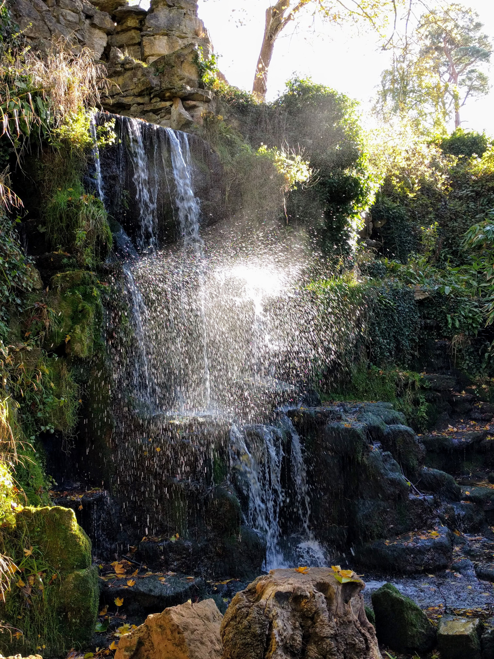 A cascade of water with sunlight highlighting droplets of water.