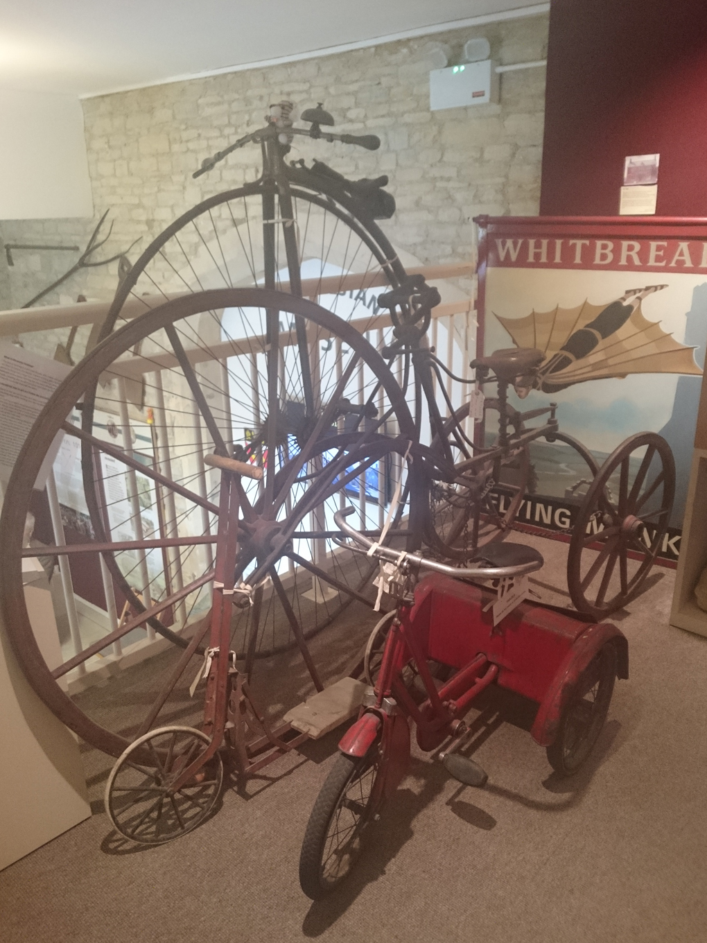 A sweet collection of antiquarian bikes consisting of a Penny Farthing, a large Victorian tricycle with a huge front wheel, a child’s tricycle and a child’s scooter, nestled in a corner of the Athelstan Museum in the lovely old town of Malmesbury.