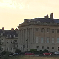 big Georgian building with all the grass in front dead and brown in the sun