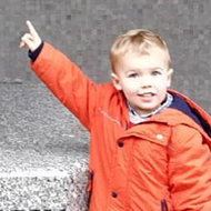 small boy pointing at statue of Chopin