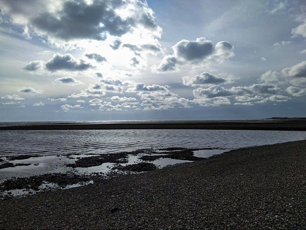 This picture shows some rays of sun breaking through the clouds with a thick black front following behind