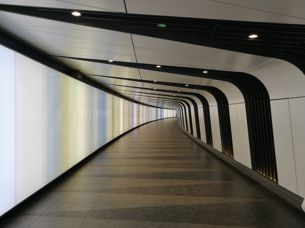 curved tunnel with walls lit up in various colours