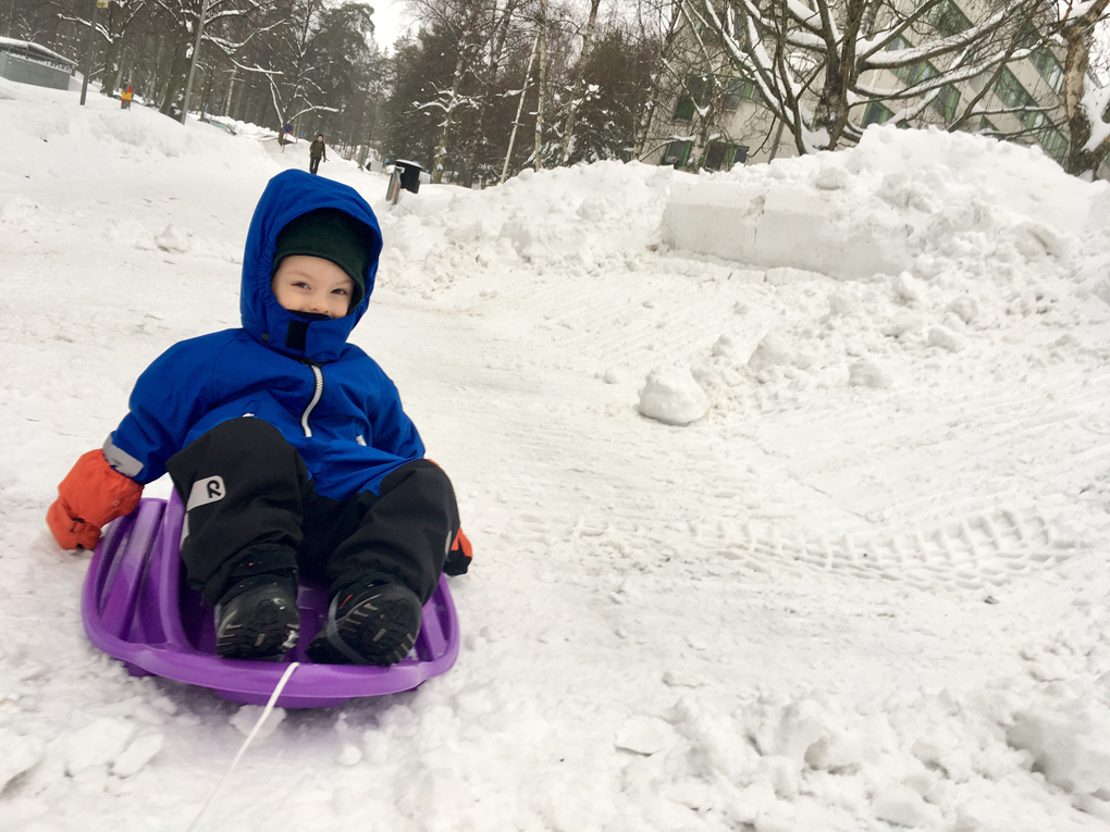 A boy on a sleigh in a snowy scenery