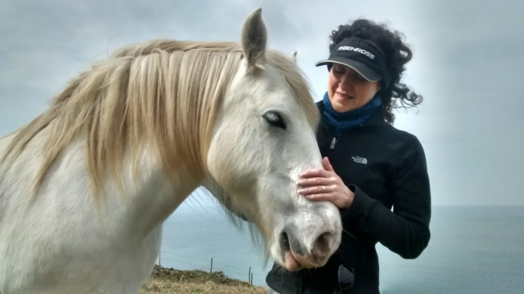 My mum stroking a happy horse