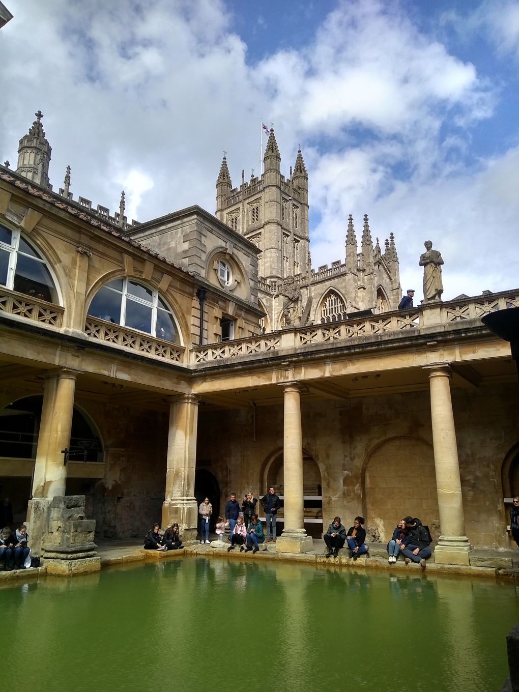 The inside of the Roman baths with Bath abbey behind