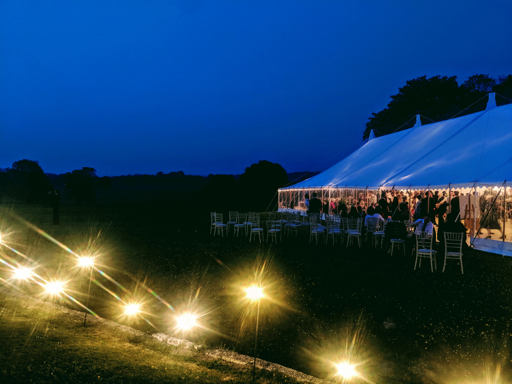 Wedding reception in field; lights and marquee