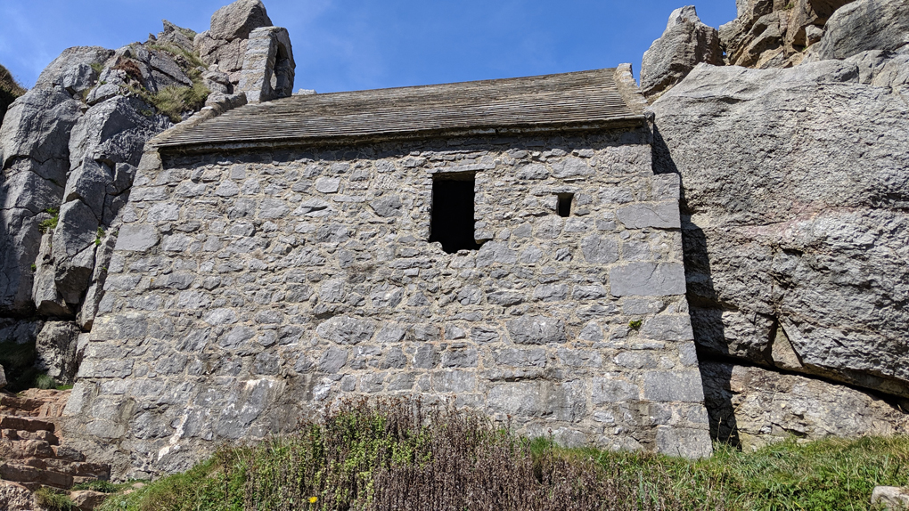 A small stone chapel built into a cliff face.