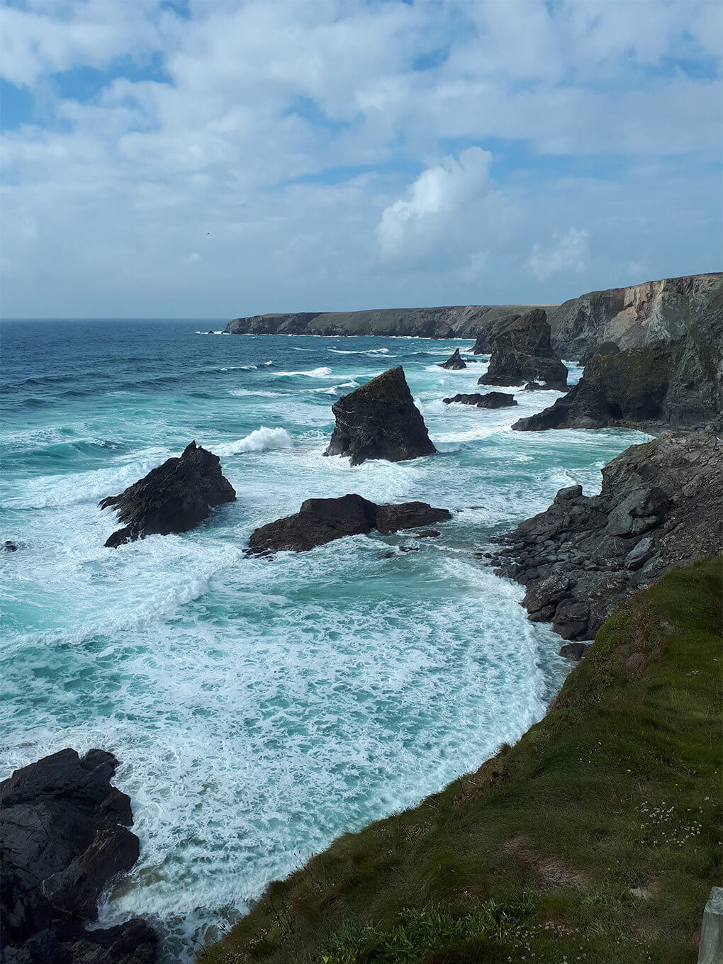 Towering, rough pillars of dark stone standing high above stormy waves
