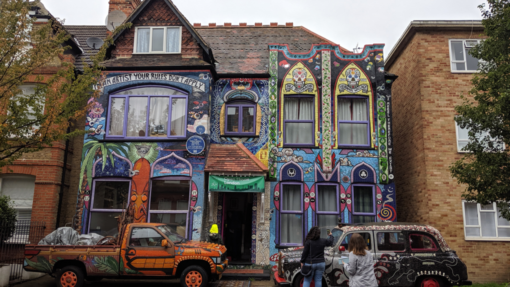 A house completely covered in colourful mosaic tiles.