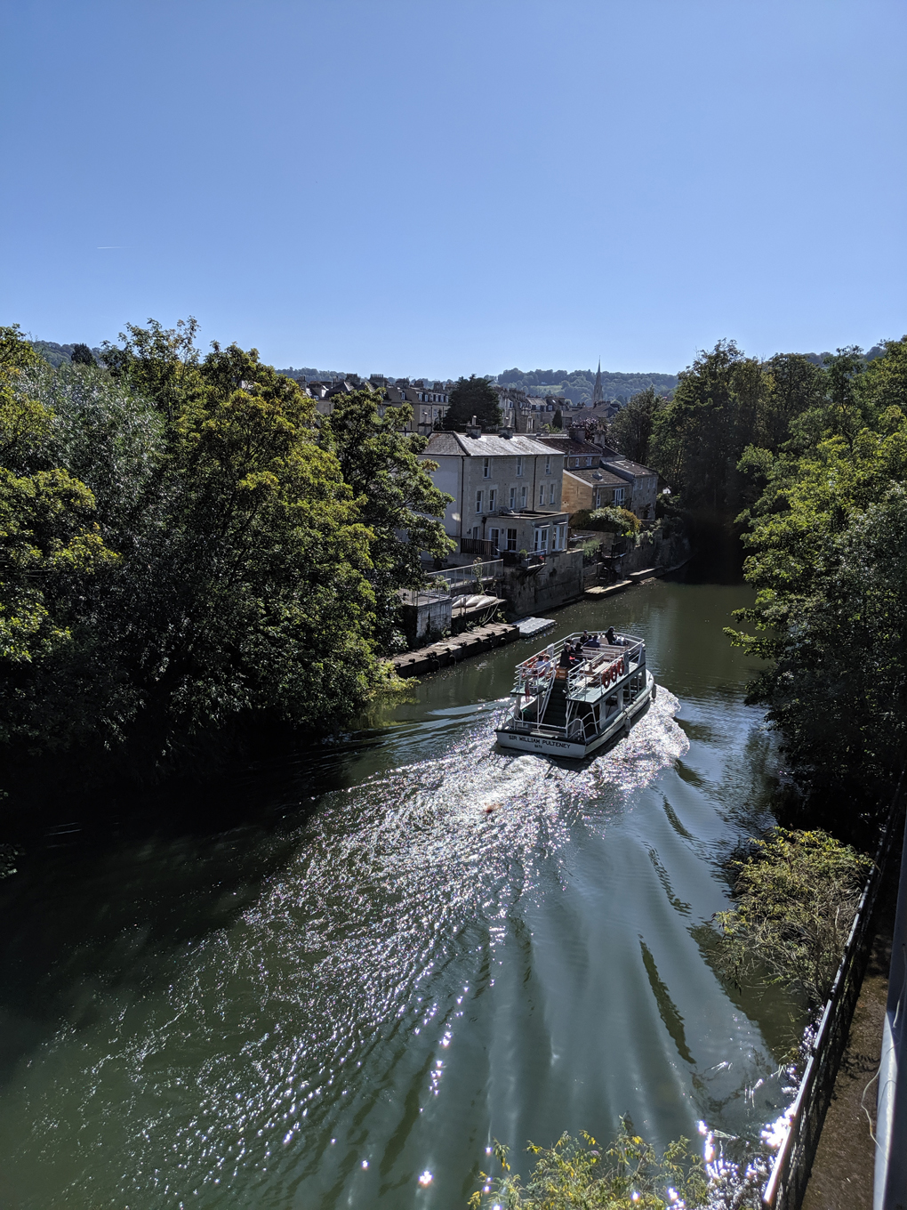 A double-decker passenger boat makes it way down the river in Bath