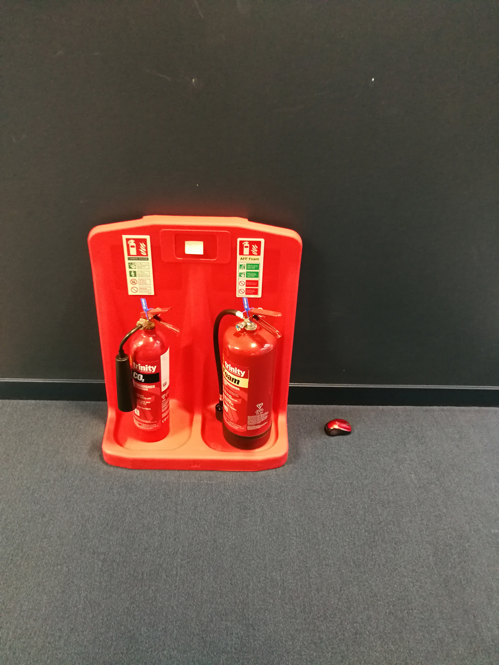 red mouse next to two red fire extinguishers