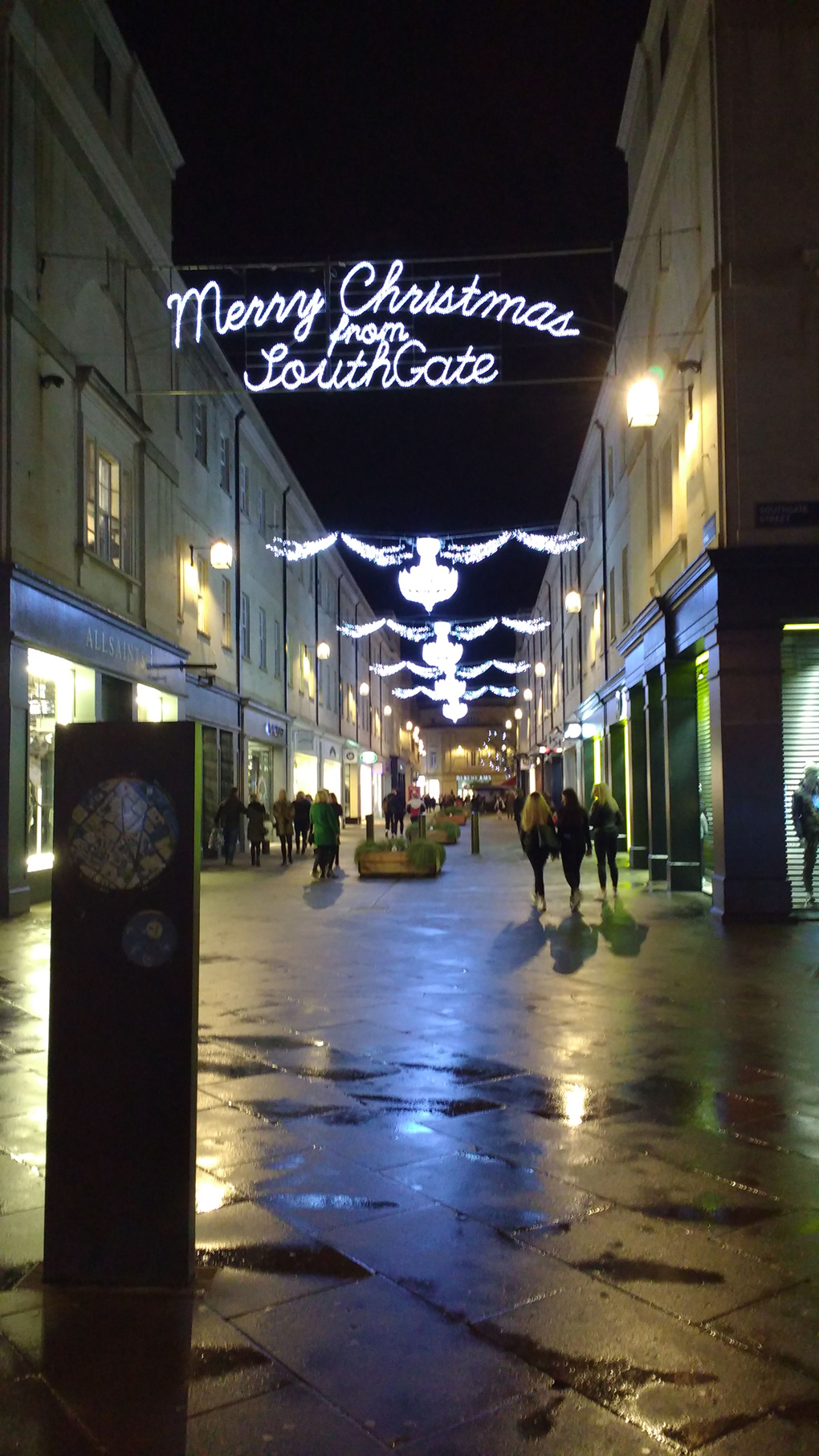 Christmas lights illuminated at night over Bath's open air shopping centre