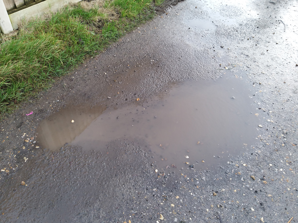 Puddle in a dirt track in the shape of guitar