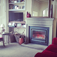 Armchairs and bookcases and log burning on the fire.