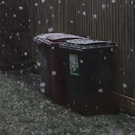 A view of the back garden with snowflakes speckled all across it.