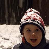 child outside a house in a snowy London street