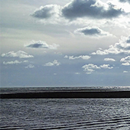 This picture shows some rays of sun breaking through the clouds with a thick black front following behind