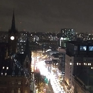 london at night from a high point, river of light along a road