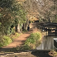 A canal on a sunny spring day, with a lock in the foreground