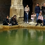 The inside of the Roman baths with Bath abbey behind