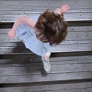 A child running down an old wooden flight of stairs shot from above