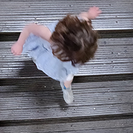 A child running down an old wooden flight of stairs shot from above