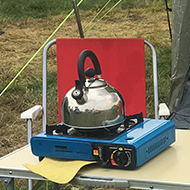 We see a picture of a welcoming tent with canopy and appliances read for cooking